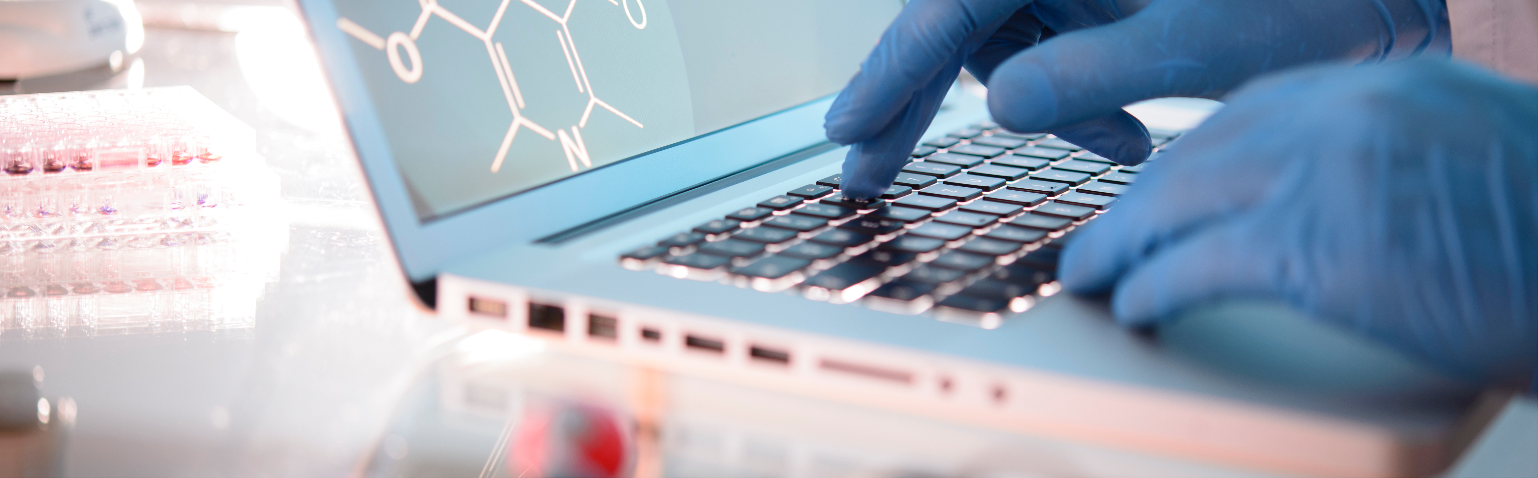 Nitrosamines. A hand in blue laboratory glove writes something on the computer keyboard.