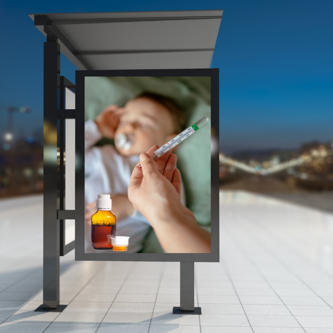 A bus stop with an advertisement for a medicinal product. The advertisement shows a small sleeping child and a woman holding a thermometer in her hand, and next to it there is a graphic depicting the advertised medicine. The city at night in the background.